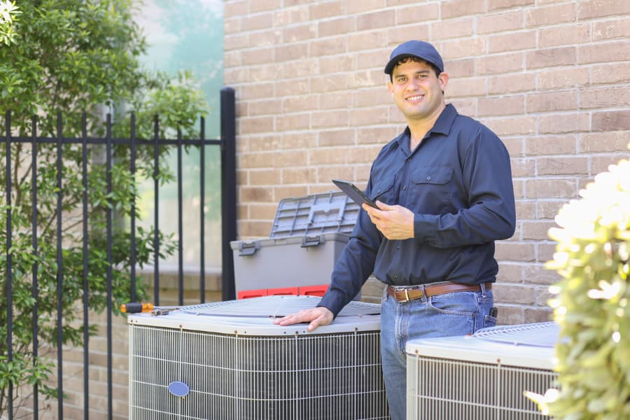 Technician at client’s home conducting air conditioner repair 