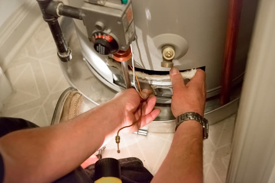 Technician inspecting hot water heater valve